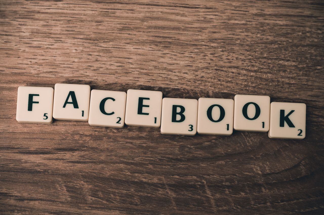 services-01 Scrabble tiles spelling Facebook on a wood background, symbolizing social media.